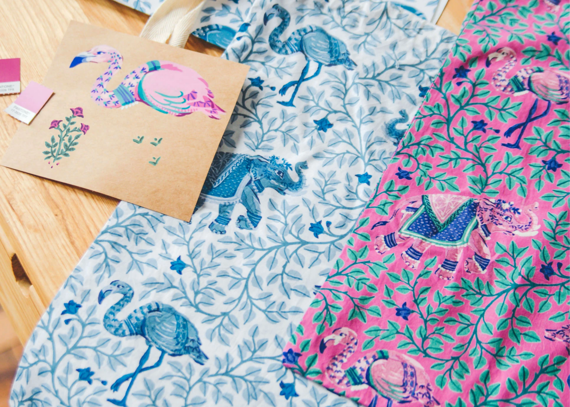 Pink and white patterned textiles with elephants and flamingos beside an illustration of the motifs.