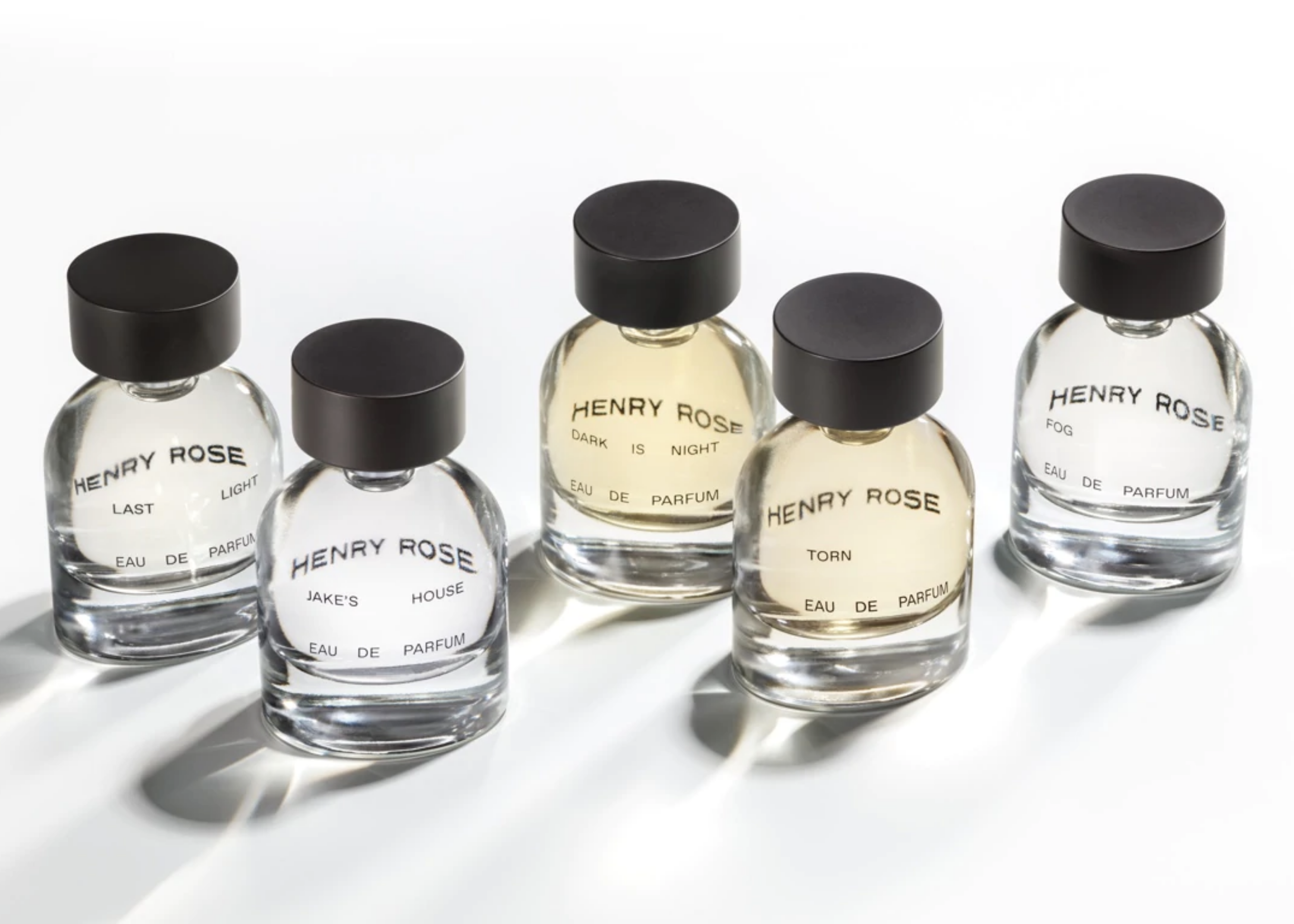 Five Henry Rose perfume bottles labeled Last Light, Jake's House, Dark Is Night, Torn, and Fog.