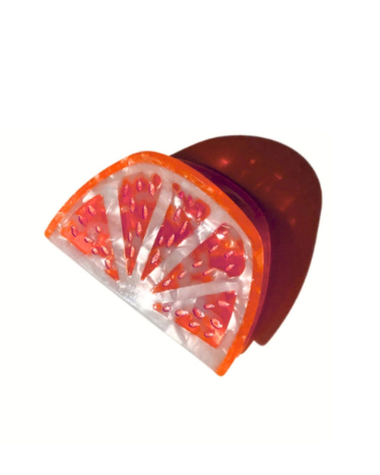 Grapefruit-slice claw hair clip shown at an angle on a white background.
